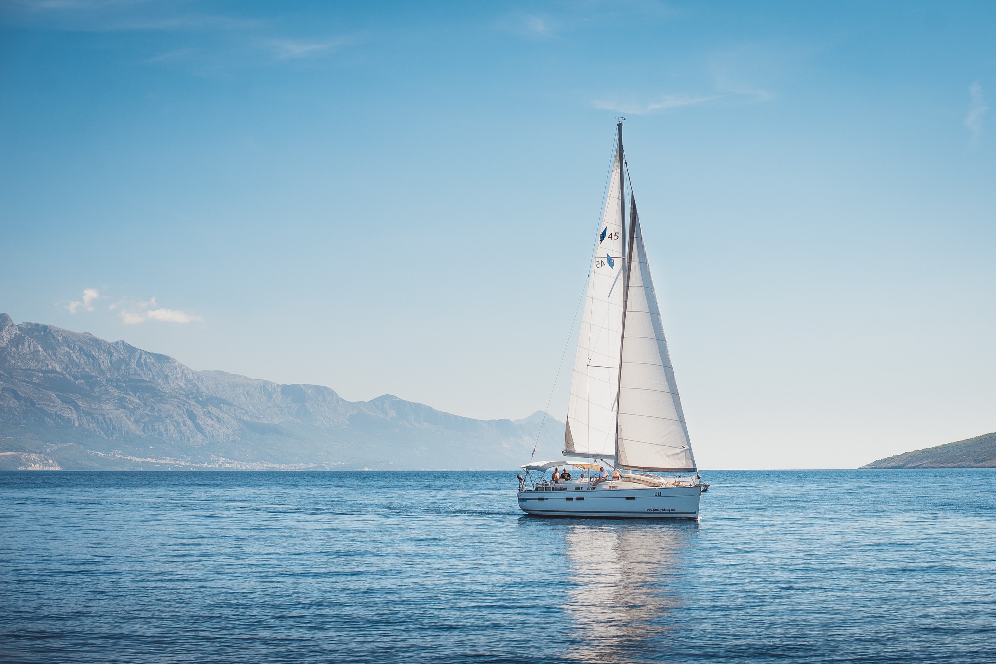 Sailing yacht in the sea against the backdrop of mountains